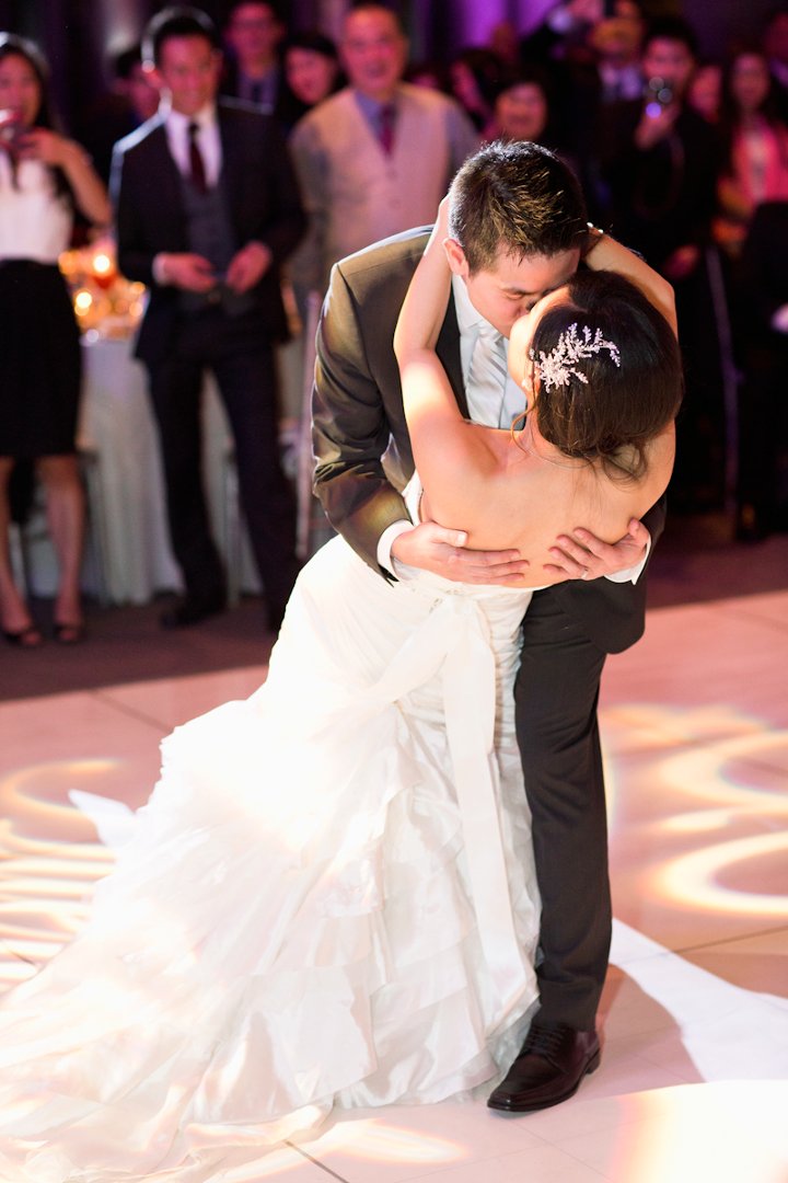 the groom kisses the bride while she is bent over on her back