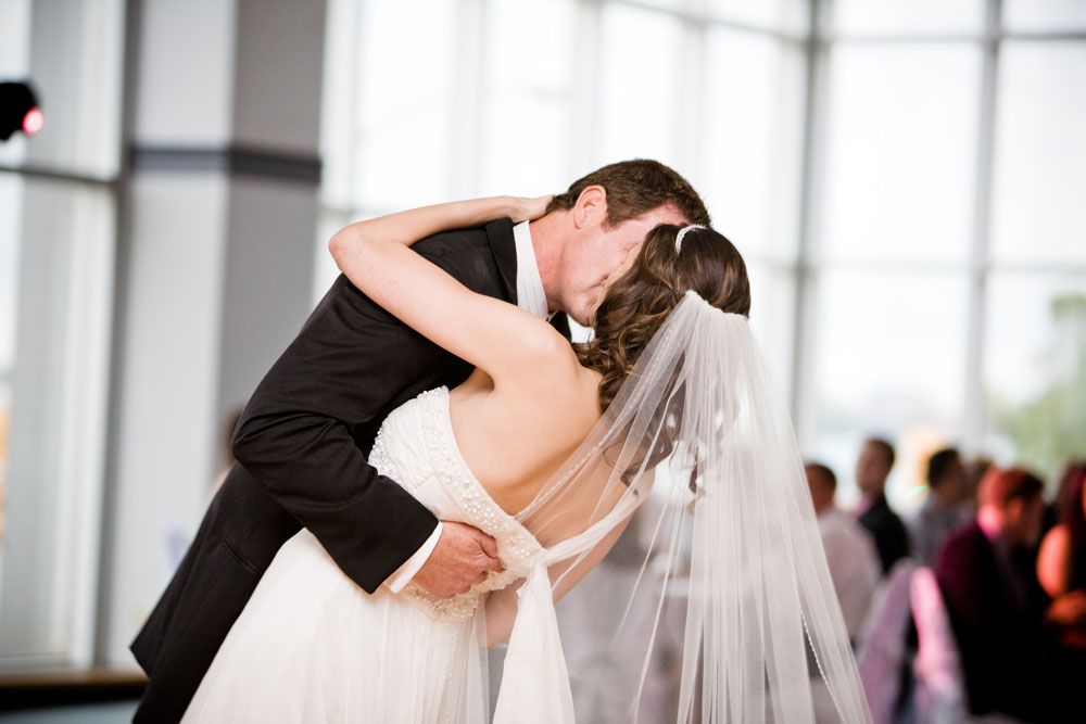 the groom kisses the bride while she is bent over on her back